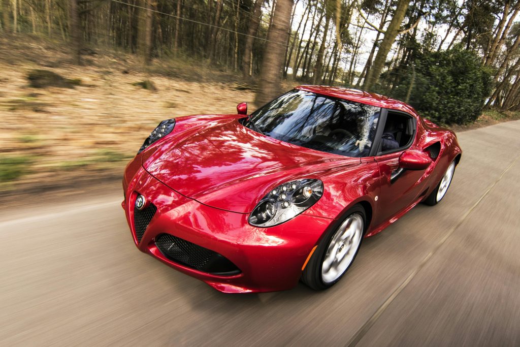 pexels photo 210019 210019 1 A sleek red sports car driving fast on a forest road, showcasing speed and luxury.